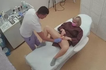 vrach osmatrivaet pisyu zhenshchiny v centre kosmetologii